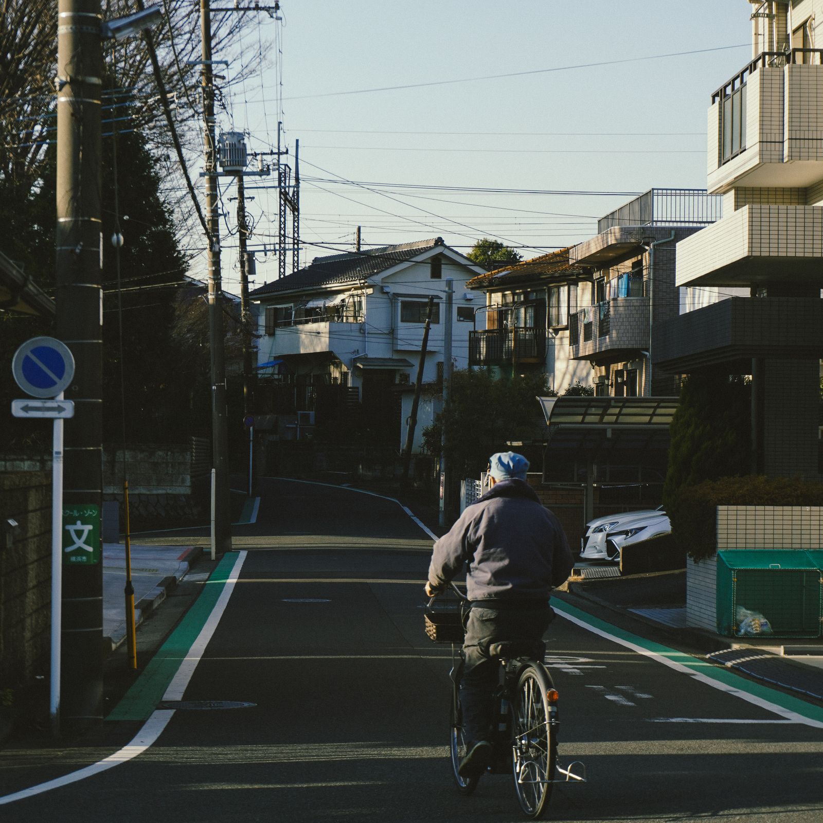 日本の住宅街を自転車で通る高齢者